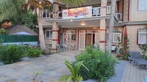 a building with a patio with a table and chairs at Soleil Vacances Bed and Breakfast in Flic-en-Flac