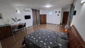 a bedroom with a bed and a table and a desk at Soleil Vacances Bed and Breakfast in Flic-en-Flac