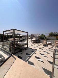 a patio with benches and tables on a roof at Corner 1 Bed Apart in Mercury Suites with Rooftop Pool Seasonal in St. Julianʼs