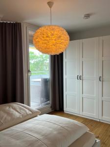 a bedroom with a bed and a large orange chandelier at Ferienwohnung Bodenseeparadies in Friedrichshafen