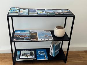 a shelf with books and a vase on it at Ferienwohnung Bodenseeparadies in Friedrichshafen