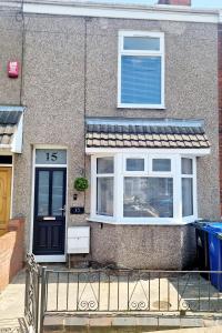 a house with a black door and white windows at Stunning 2 Bed House, Cleethorpes - Contractors Welcome! in Cleethorpes +6 photos