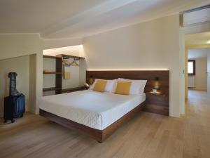 a large bedroom with a large bed with white sheets at Portica Homes Assisi in Assisi