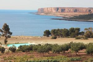 a view of the ocean from a hill with a pool at Country Villa San Vito Bay in San Vito lo Capo