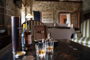 a table with two glasses and a bottle of wine at Château de la Motte Beaumanoir in Pleugueneuc +39 photos