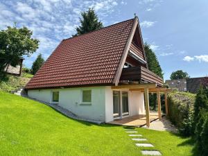 a small white house with a brown roof at 2 Wohnungen im Haus mit Sauna & Bergblick, 2 Küchen, 2 Bäder in Siegsdorf
