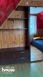 a bedroom with a large wooden wall with a mirror at Relax House Zviahel in Zwiahl
