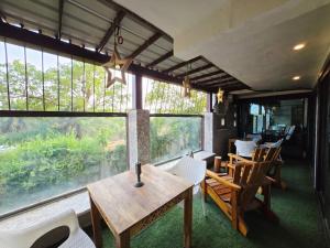 a dining room with a table and chairs and windows at Richhariya Nature's Retreat Homes in Jhānsi
