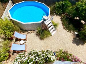 a swimming pool with two chairs and a bath tub at Casa da Aldeia in Santa Bárbara de Nexe
