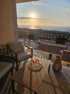 a balcony with a table and two glasses of wine at Il Dolce Tramonto Apartment in Trinità dʼAgultu