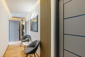 a corridor with two chairs and a table in a room at Margareta Apartments in Odorheiu Secuiesc