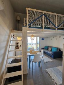 a room with a loft bed and a dining room at Il Dolce Tramonto Apartment in Trinità dʼAgultu