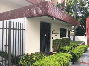 a small house with a black door and some bushes at Apartamento Inteiro - Duplex no Panamby - Próximo do Estádio do Morubi - Hospital Albert Einstein - Expo Transámerica - Shopping Jardim Sul e Morumbi Towm - Consulado Americano in Sao Paulo +2 photos