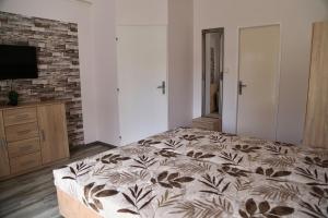 a bedroom with a bed and a flat screen tv at Apartmány Adriana in Veľký Meder