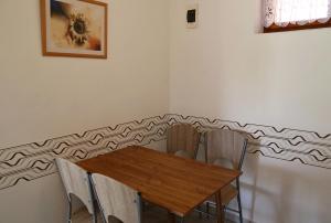a dining room with a wooden table and chairs at Apartmány Adriana in Veľký Meder