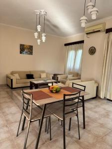 a living room with a wooden table and chairs at Val's place in Mytilini +20 photos