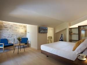 a hotel room with a bed and a table and chairs at Portica Homes Assisi in Assisi