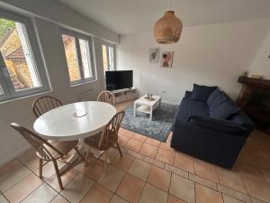 a living room with a table and a couch at Petite maison au pied du château in Salignac Eyvigues