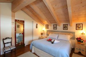 リヴィーニョにあるAntico Chalet - Happy Rentalsのベッドルーム1室(花の咲く大型ベッド1台付)