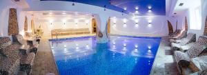 a large swimming pool with blue water in a building at Sosnovel in Voropayev