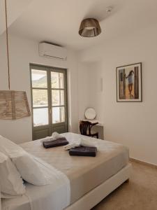 a bedroom with a large bed with two towels on it at VERANNA Patmos in Patmos