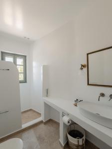 a white bathroom with a sink and a mirror at VERANNA Patmos in Patmos