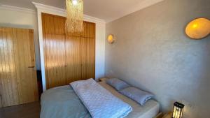 a bedroom with a bed with blue pillows on it at Apartment with 180 Seaview in Asilah
