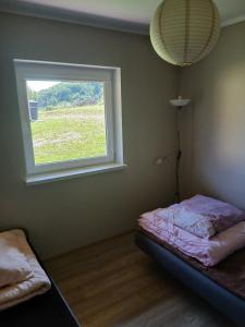 a bedroom with a bed and a window at Tęczowe Wzgórze Bieszczady 887 - 507 - 298 in Wołkowyja