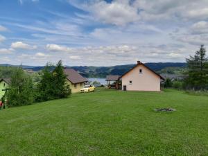 a yard with a house and a car in a field at Tęczowe Wzgórze Bieszczady 887 - 507 - 298 in Wołkowyja
