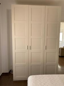 a white closet with white doors in a bedroom at Tu Refugio en la Costa del Sol, Playa y Centro a un Paso in Fuengirola