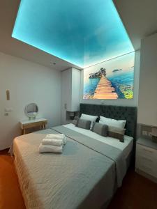 Un dormitorio con una cama grande con un cuadro en la pared. en Dina Studio Apartments, en Pefkohori