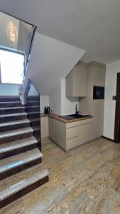 a kitchen and a staircase in a house at Willa Zacisze Szczawnica 15 m2 in Szczawnica