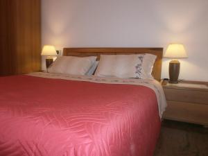 a bedroom with a bed with a red blanket and two lamps at B&B Dosso Quarel in Costermano