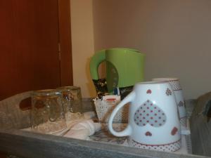 un mostrador con dos tazas de café y vasos. en B&B Dosso Quarel, en Costermano