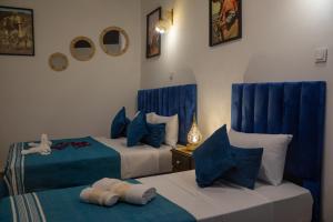 two beds in a room with blue and white at Riad Soufiya Palace - Silent Luxury in Fès