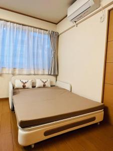 un lit d'hôpital dans une chambre avec fenêtre dans l'établissement Mokuga apartment, à Tokyo 46 autres photos