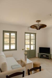 a living room with a couch and a tv at VERANNA Patmos in Patmos