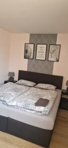 a bed in a bedroom with pictures on the wall at Katrins Ferienwohnung in Hammelburg
