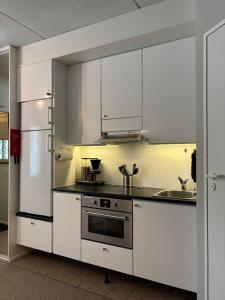 a kitchen with white cabinets and stainless steel appliances at Sisältää 2x Ruka ranneke - kausikortit kesä&talvi - Vuosselin Helmi C11 in Ruka