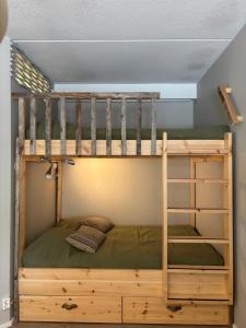 a bunk bed in a room with a ladder at Ski-in Vuosselin Helmi C11 - 2x hissiliput ski passes in Ruka +12 photos