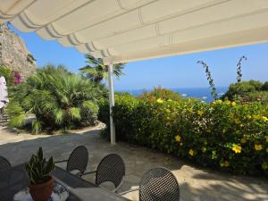 een tafel met stoelen en uitzicht op de oceaan bij Villa Sterlizia in Capri