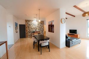 een woonkamer met een tafel en een bank bij Stylish Dairy Cottage by the Sea- Romantic Luxury in Port Elliot