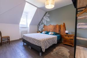een slaapkamer met een bed met een houten hoofdeinde bij Appartement cosy centre historique in Thann