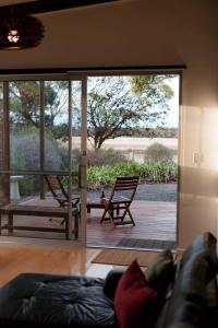 een woonkamer met een glazen schuifdeur naar een patio bij Stylish Dairy Cottage by the Sea- Romantic Luxury in Port Elliot +56 foto's