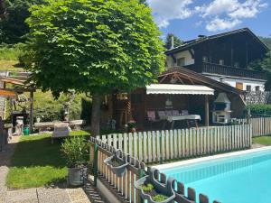a fence around a pool in front of a house at Haus Nelsen - Wohlfühlapartments mit HochkönigCard in Dienten am Hochkönig
