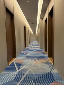 un corridoio con pavimenti in moquette colorata in un edificio di 合悦精品商务酒店 a Roga