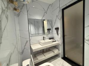 un bagno con lavandino, specchio e WC di 合悦精品商务酒店 a Roga Altre 37 foto