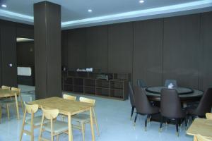 una sala da pranzo con tavoli e sedie in legno di 合悦精品商务酒店 a Roga