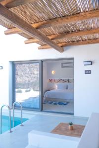 sypialnia z łóżkiem i dużym szklanym oknem w obiekcie FarOut - BeachResort & Camping w mieście Mylopotas