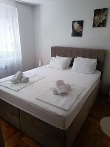 a white bed with two towels on top of it at Trnsko in Zagreb